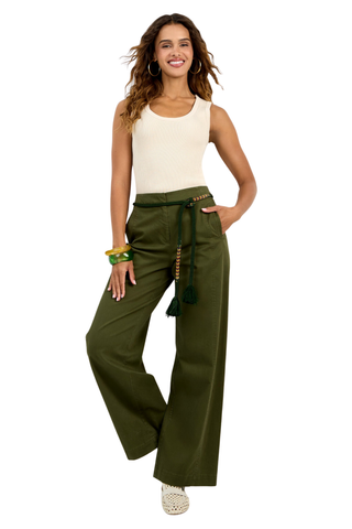 Woman wearing green wide-leg pants and a beige top on a white background