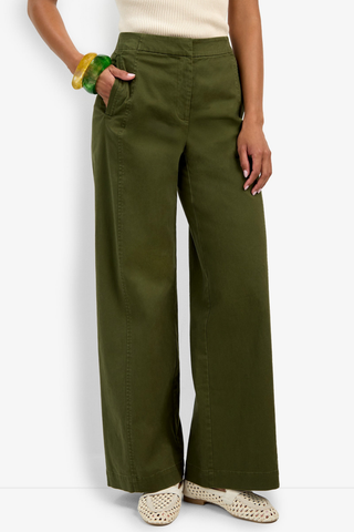 Person wearing olive green wide-leg pants on a white background