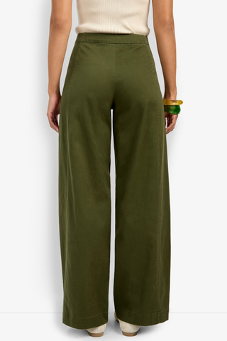 Person wearing olive green wide-leg pants on a white background