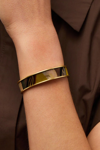 Brackish Laramie Thin Cuff bracelet featuring handcrafted golden peacock, pheasant, and turkey feathers set in a 24K gold-plated adjustable cuff bracelet.