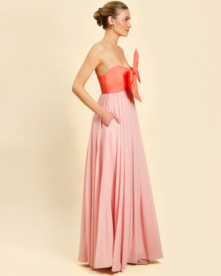 Mestiza Kiss Me Knot Gown in Bloom Pink featuring a strapless chiffon silhouette with an oversized statement bow and flowing skirt.