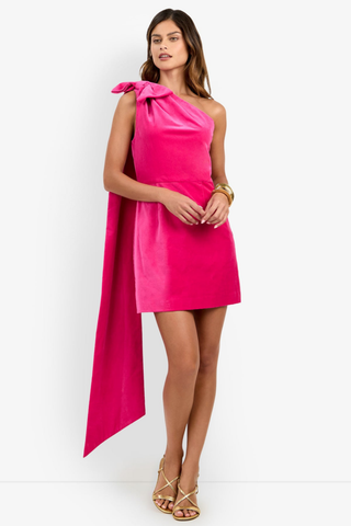 Trina Turk Romance 2 Dress in Tormalina pink featuring a one-shoulder neckline, oversized bow with cascading train, and a fitted velveteen mini silhouette.