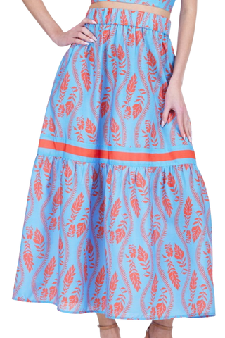 Full tiered midi skirt in blue with coral botanical fern print and grosgrain ribbon trim at hem, shown styled as separates on model.