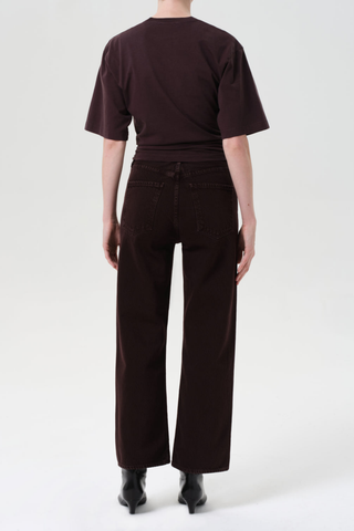 Model wearing the AGOLDE Ren Jean in Sloe Berry featuring a high-rise waist, cropped wide-leg silhouette, and rich dark grape denim with warm brown undertones.