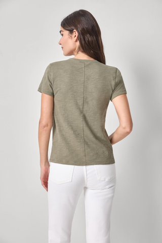 Model wearing the Lilla P Short Sleeve Back Seam V-Neck in Fern featuring soft slub cotton fabric, short sleeves, a V-neckline, and subtle back seam detail paired with white denim jeans