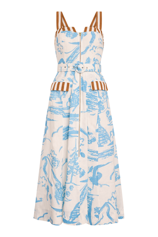 Model wearing the Olivia by Livro Foster Dress in Basket Trail, featuring a structured bodice, adjustable straps, full A-line skirt, side pockets, and a soft blue and neutral botanical print.