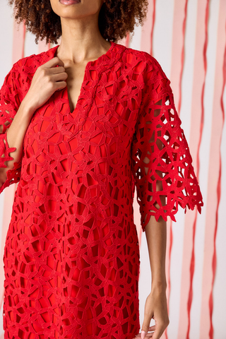 Model wearing Crosby Alice Tunic Dress in Pomegranate Lace, a red lace tunic mini dress with elbow-length sleeves and scalloped detailing