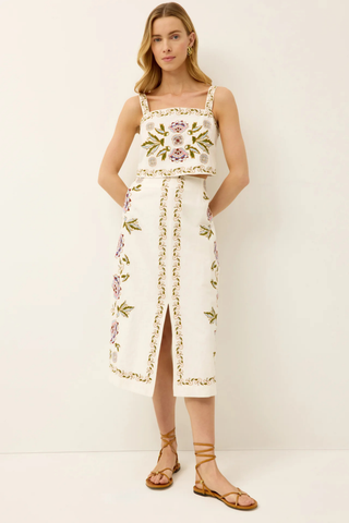 Ivory midi skirt with floral embroidery and front slit.