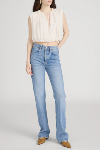 Model wearing FRAME The Vertical Jean in Static, a high-rise straight-leg rigid denim jean in a light vintage wash