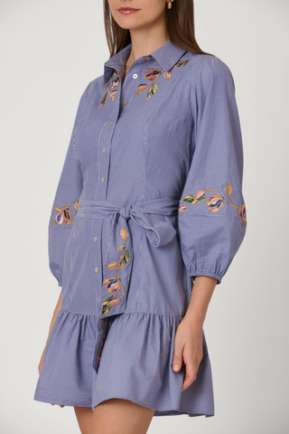 Blue dress with floral embroidery on a plain background