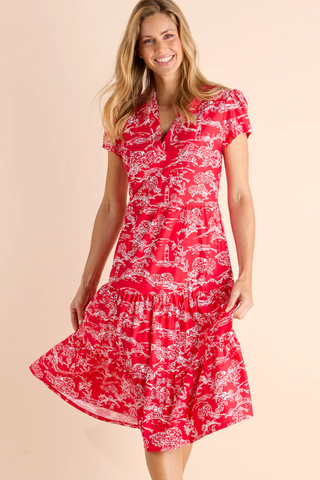 Woman wearing a red floral dress on a beige background