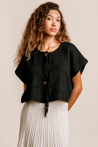Kerisma Sachi Vest in Black featuring a cropped silhouette, short sleeves, and fringed button front in soft marled yarn.