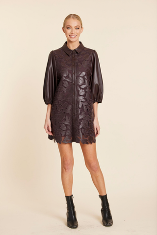 Dolce Cabo Laser Cut A-Line Dress in Coffee featuring brown faux leather, floral cutout detailing, puff sleeves, and an A-line mini silhouette.