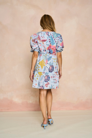 Blue floral mini dress with puff sleeves, tiered skirt, and tie waist