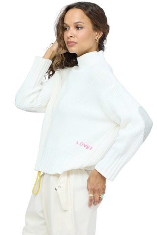 Kerri Rosenthal Marlow Imperfect Heart Sweater in Natural featuring a soft ivory rib knit, mock neck, and contrast heart elbow patches.