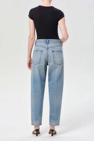 Model wearing AGOLDE The 80’s Jean in Orbital, a high-rise straight-leg rigid denim jean in a medium vintage indigo wash
