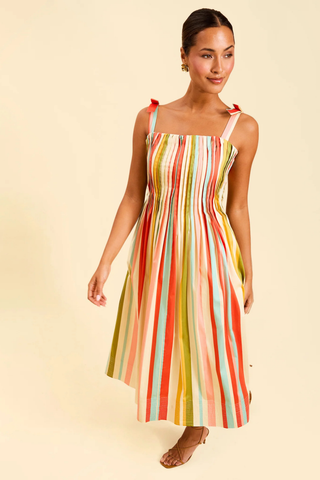 Model wearing Mestiza Anais Pintuck Midi Dress in Paradise Stripe featuring a pintucked bodice, bow straps, and colorful striped midi silhouette