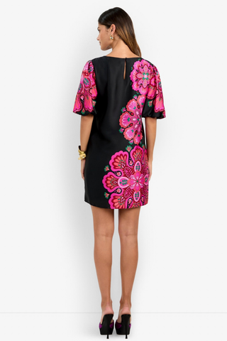 Trina Turk Luv Dress in Multi featuring a black mini silhouette with oversized pink floral print, boat neckline, and short bubble sleeves.