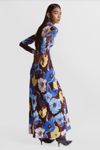 De Loreta Mandy Dress featuring a colorful oversized floral print, long sleeves, high neckline, and maxi silhouette.