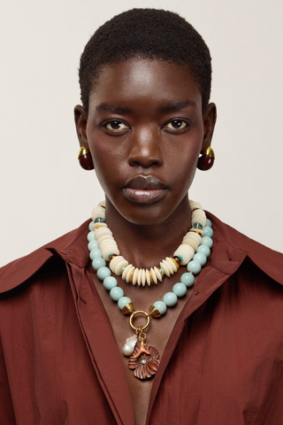 Desert Bloom Necklace in Amazonite with pale blue-green beads, gold-plated hardware, pearl, coral-inspired and carved flower charms.
