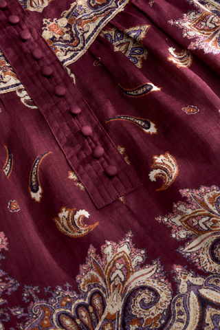 Rhiannon Top in Majesty featuring a rich purple paisley print, stand collar, button front, and full gathered long sleeves.
