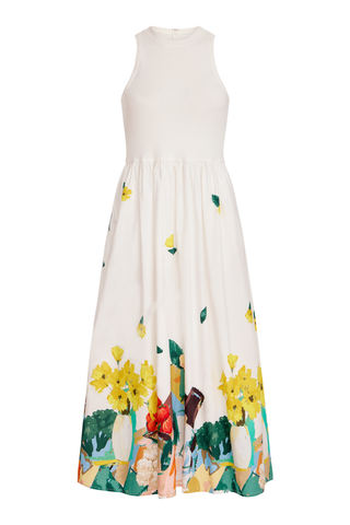 Model wearing the Olivia by Livro Elsie Dress in Farmer's Market, featuring a cream ribbed bodice, racerback silhouette, flowing cotton midi skirt, and a colorful produce-inspired print along the hem.