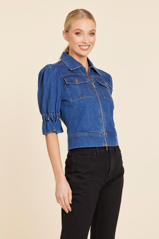 Dolce Cabo Puff Sleeve Shacket in Denim featuring medium wash denim, elbow-length puff sleeves, a pointed collar, zip front, and chest flap pockets.