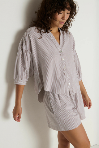 Model wearing the Nation LTD Jaynee Blouse in Praline Stripe, a lightweight striped button-front blouse featuring a relaxed fit, classic collar, three-quarter sleeves, and a breezy textured woven fabric.
