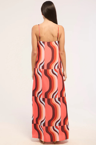 Model wearing the MISA Lark Dress in Retro Riviera featuring adjustable spaghetti straps, a straight neckline, colorful abstract satin print, and a flowing maxi silhouette.