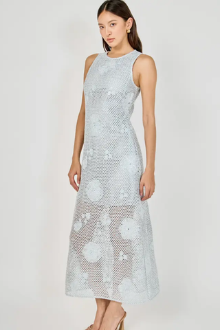 Woman wearing a light blue floral lace dress on a white background
