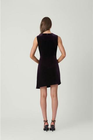 Shoshanna Lee Dress in Dark Plum featuring stretch velvet, a draped fitted bodice, bow waist detail, and asymmetrical mini skirt.