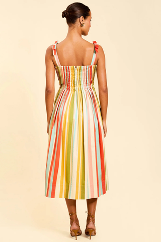 Model wearing Mestiza Anais Pintuck Midi Dress in Paradise Stripe featuring a pintucked bodice, bow straps, and colorful striped midi silhouette