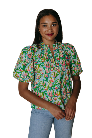 Model wearing the Laroque Alix Blouse in Champs De Fleurs featuring a vibrant floral print, puff sleeves, and split neckline
