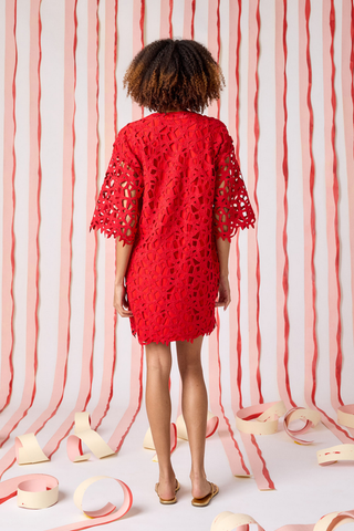 Model wearing Crosby Alice Tunic Dress in Pomegranate Lace, a red lace tunic mini dress with elbow-length sleeves and scalloped detailing