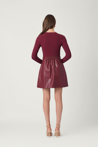 Shoshanna Meritt Dress in Burgundy featuring a fitted ribbed knit bodice, faux leather A-line mini skirt, and gold-tone waist hardware.