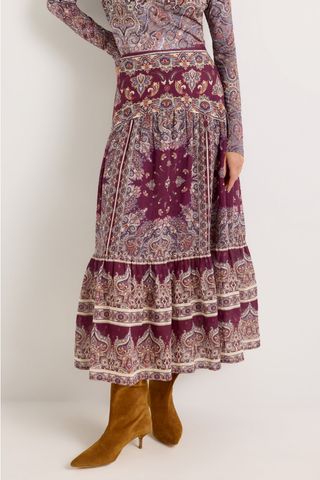 Holland Skirt in Majesty featuring a purple and neutral paisley print, fitted drop waist, and flowing tiered midi silhouette.