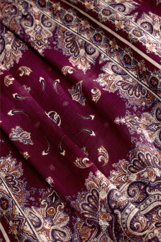 Holland Skirt in Majesty featuring a purple and neutral paisley print, fitted drop waist, and flowing tiered midi silhouette.
