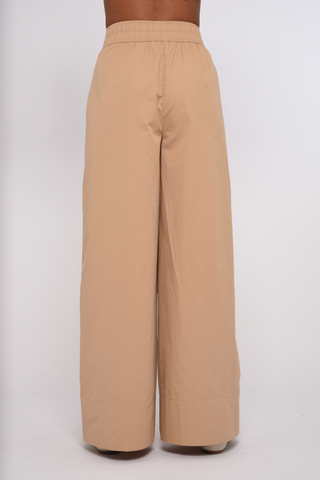 Model wearing the Love the Label Ramona Pant in Sand Dust featuring a high-rise waist and wide-leg silhouette.