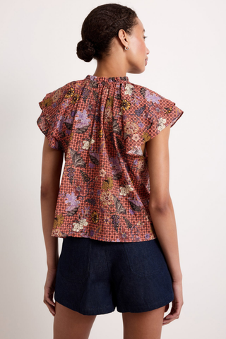Marie Oliver Hartley Top in Cassia featuring a colorful floral print, flutter sleeves, and adjustable tie neckline with beaded ends.