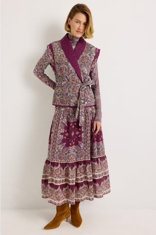 Holland Skirt in Majesty featuring a purple and neutral paisley print, fitted drop waist, and flowing tiered midi silhouette.