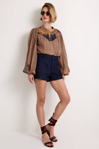 Marie Oliver Rhiannon Top in Flores featuring a brown mixed print, contrasting yoke, stand collar, button placket, and long gathered sleeves.