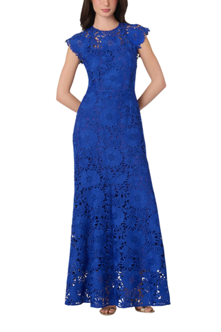 Model wearing the Shoshanna Raven Dress in Cobalt featuring lace fabrication, illusion neckline, scalloped sleeves, and a full-length silhouette.