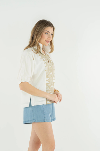 Woman wearing a white blouse with lace details and a denim skirt on a white background