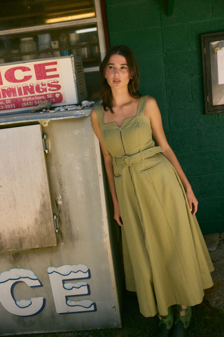Olivia by Livro Foster Dress in Olive featuring a sleeveless midi silhouette, waist tie, and full skirt.