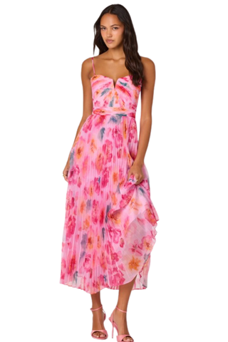 Woman wearing a pink multi floral pleated midi dress with spaghetti straps and fitted bodice from ASTR on a white background.