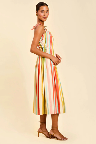 Model wearing Mestiza Anais Pintuck Midi Dress in Paradise Stripe featuring a pintucked bodice, bow straps, and colorful striped midi silhouette