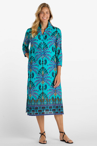 Model wearing the Jude Connally Kallan Dress in Peacock Garden Black featuring a colorful Peacock Garden print and midi silhouette.