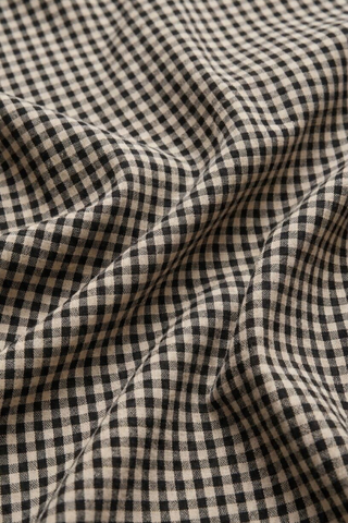 Model wearing the Z Supply Merit Gingham Top in Black with a sleeveless silhouette and elasticized hem.