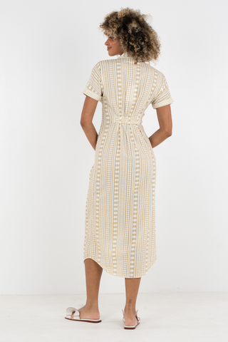 Woman wearing a beige checkered dress on a white background
