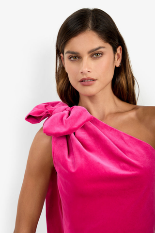 Trina Turk Romance 2 Dress in Tormalina pink featuring a one-shoulder neckline, oversized bow with cascading train, and a fitted velveteen mini silhouette.